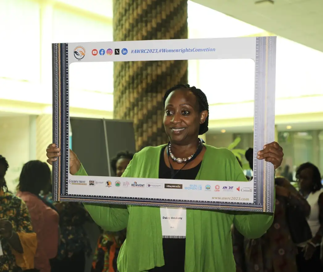 Woman holding a branded photo frame at the AWRC2023 women's rights convention