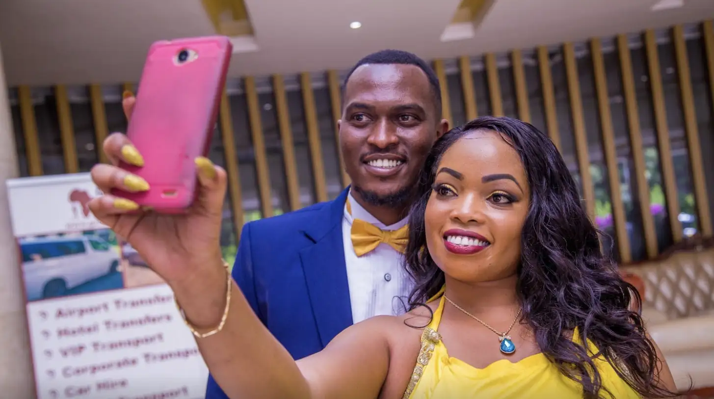 A couple in formal wear taking a selfie at an event